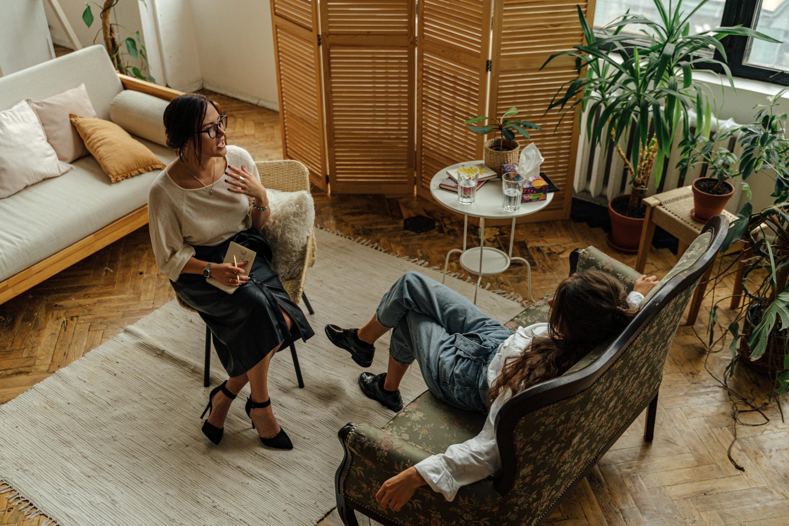 Deux femmes parlent, elles sont assises face à face dasn des fauteils confortables